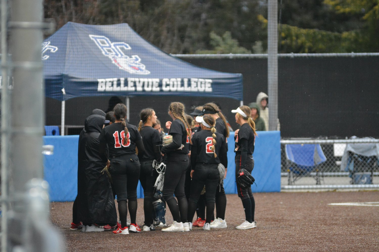 The Yelm High School softball team huddles before taking the field for the second inning during a game against Ellensburg at Bellevue College on Friday, March 24.