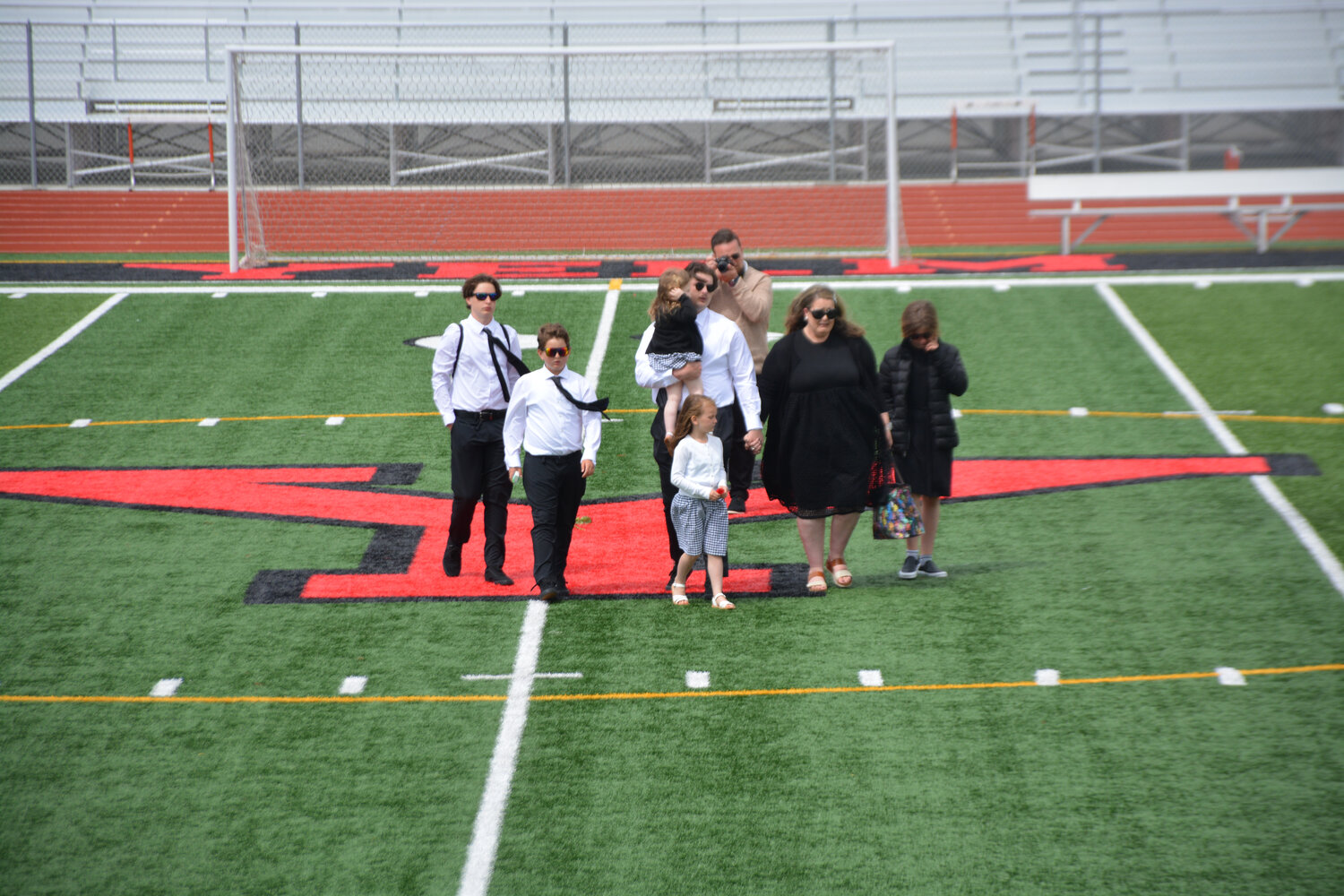The Jemtegaard family leaves the field after they placed roses in honor of their late father and husband.