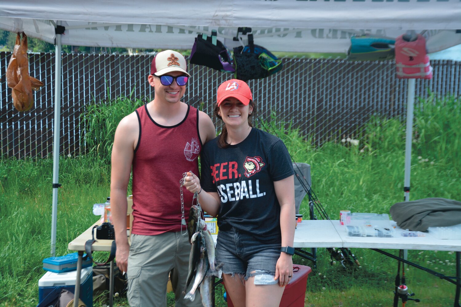 Paige and Brian Bursley hold up their catches at Lake Lawrence following a Backcountry Hunters and Anglers event on Saturday, May 20.