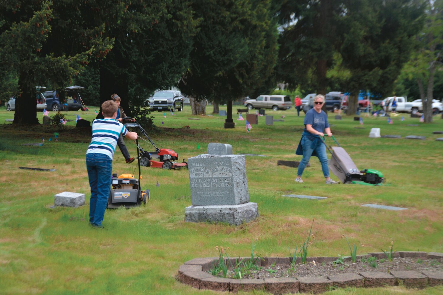 Volunteers make their rounds with lawn mowers at the Roy Cemetery during a cleanup day event on Sunday, May 21.
