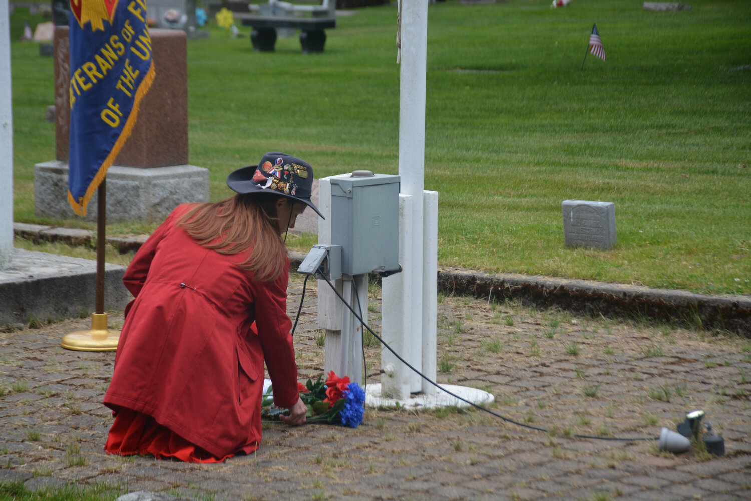 Marie Vilsack places blue flowers to honor those who gave the ultimate sacrifice on Memorial Day at the Yelm Cemetery.