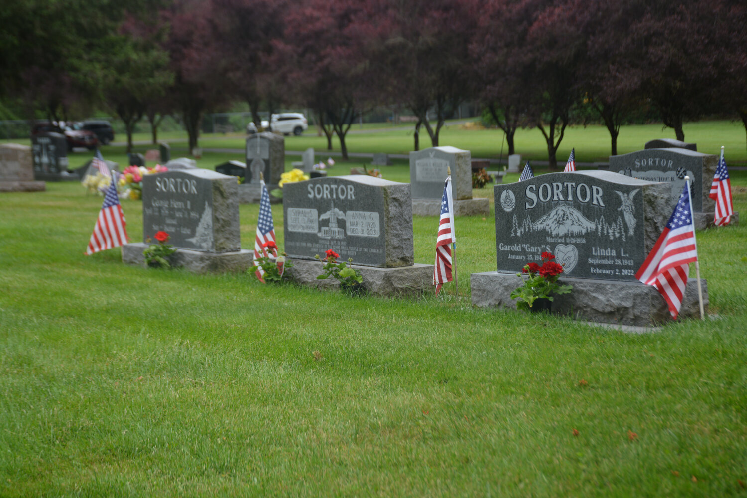 Three tombstones bear American flags at the Yelm Cemetery on Memorial Day.