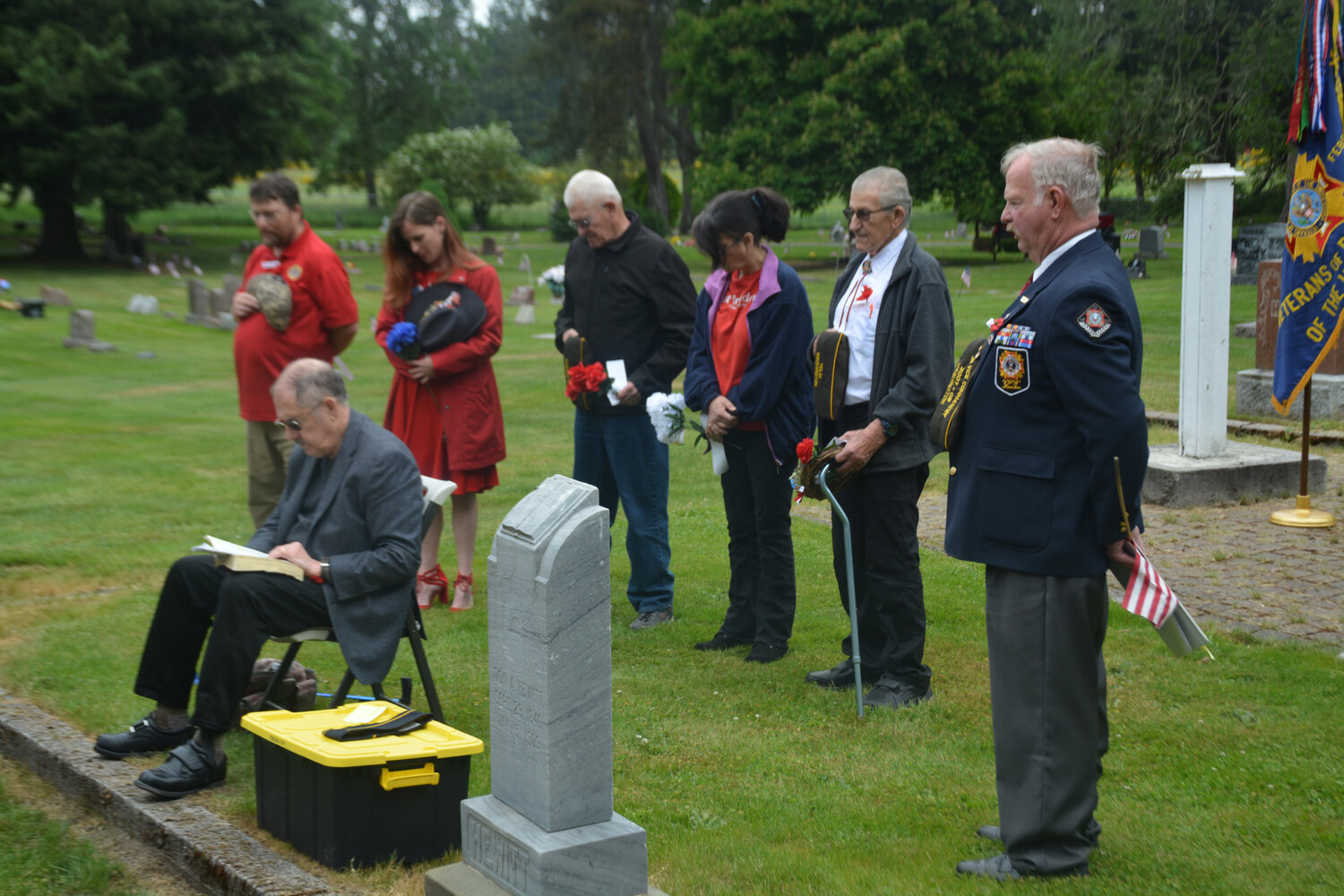 Event organizers bow their heads as James A. Smith leads a prayer at a Memorial Day ceremony at the Yelm Cemetery on Monday, May 29.