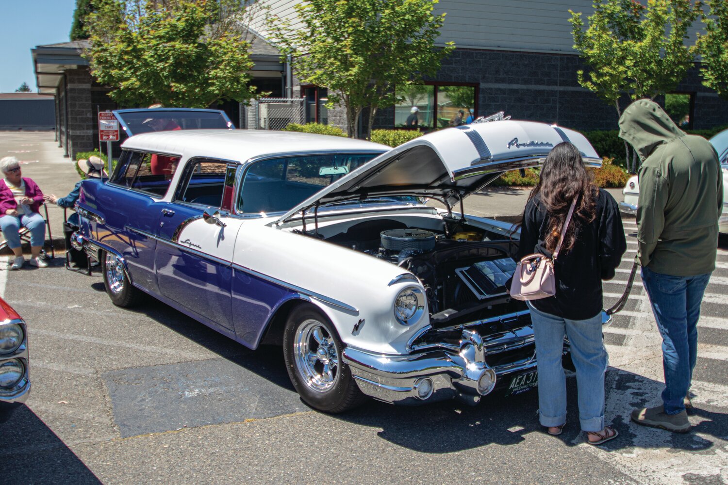Car show attendees check out Thomas Kelly’s 1956 Pontiac Safari Wagon on Sunday, June 4, at the Yelm High School car show.
