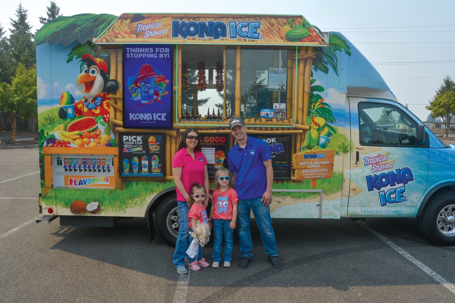 Matt and Melinda Duprel smile in front of their Kona Ice truck with their two children.