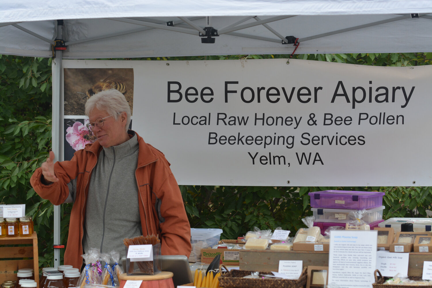 Karla Borschinski discusses Bee Forever Apiary’s product with a customer on Sept. 30 at the final Yelm Farmers Market of the year.