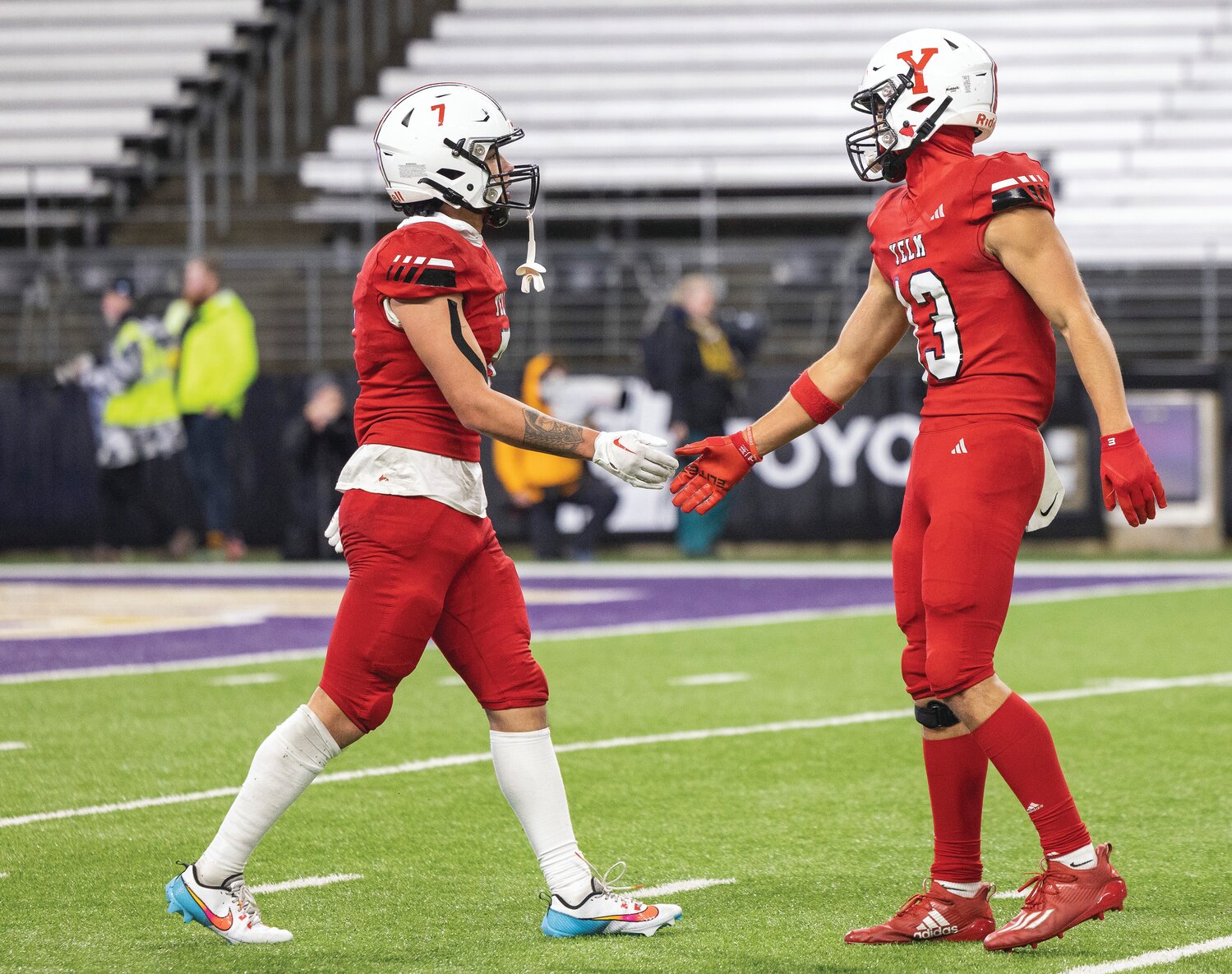 Yelm’s Marius Aalona (7) high fives wide receiver Gio Sanchez (13) during the 3A state championship game at Husky Stadium on Friday, Dec. 1.