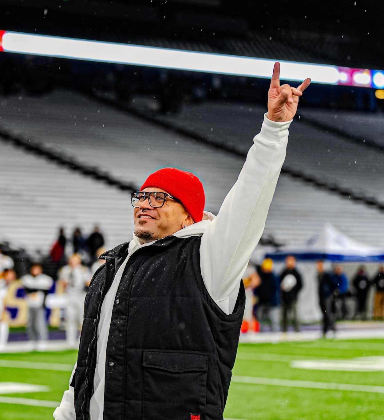 Nui Aalona, 1999 Yelm graduate, smiles after the conclusion of his rendition of the national anthem at the 3A football championship game, Friday, Dec. 1 at Husky Stadium.