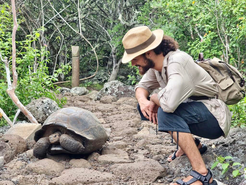Julian Garcia visits a tortoise in the Galapagos Islands during his voyage.